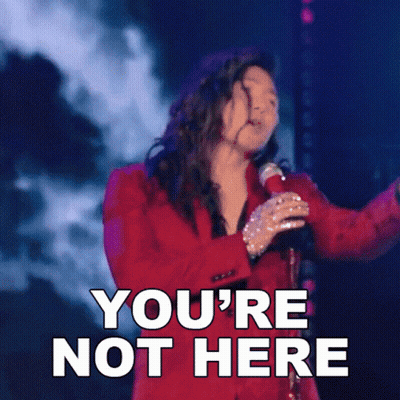 A Woman In A Red Suit Singing Into A Microphone With The Words You 'Re Not Here Above Her GIF