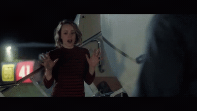 A Woman In A Red Sweater Stands In Front Of A Sign That Says 41 GIF