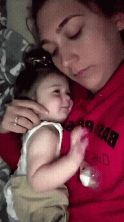 A Woman In A Red Sweatshirt Holds A Baby GIF