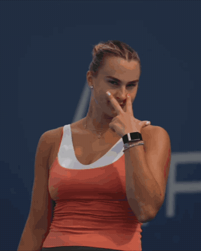 A Woman In A Red Tank Top Is Pointing At Something GIF