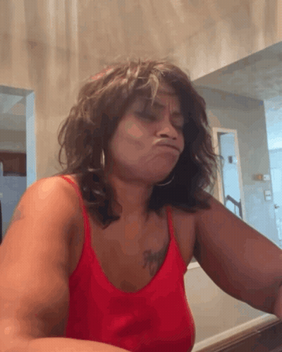 A Woman In A Red Tank Top With A Tattoo On Her Chest GIF