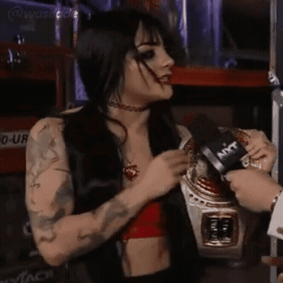 A Woman In A Red Top Is Being Interviewed By A Man With A Microphone That Says Ant On It GIF