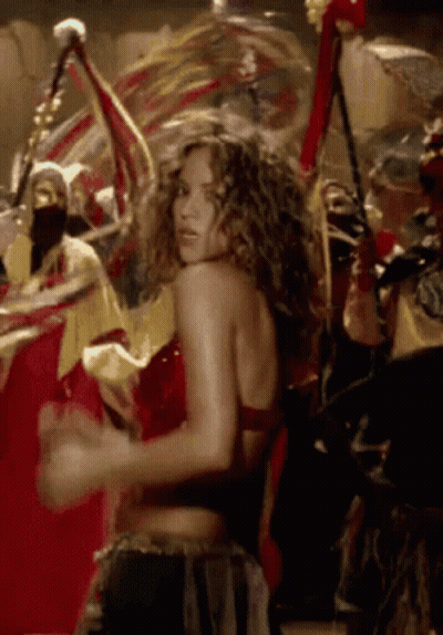 A Woman In A Red Top Is Dancing In A Crowd Of People GIF