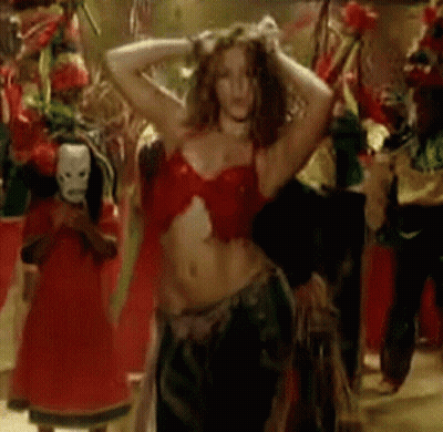 A Woman In A Red Top Is Dancing In A Crowd Of People GIF