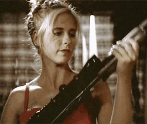 Woman In Red Top Holding Rifle GIF