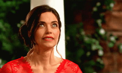 A Woman In A Red Top Is Looking Up At Something GIF