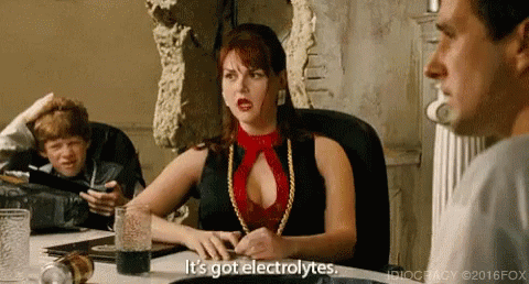 A Woman In A Red Top Is Sitting At A Table With A Glass Of Water And A Man . GIF