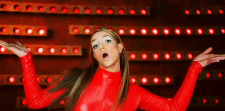 A Woman In A Red Top Is Standing In Front Of A Wall Of Red Lights . GIF