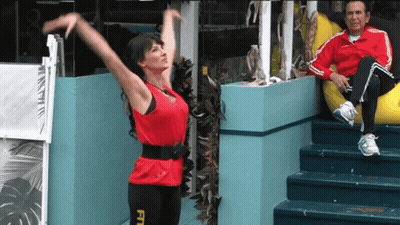 A Woman In A Red Top With The Word Fit On Her Leggings GIF
