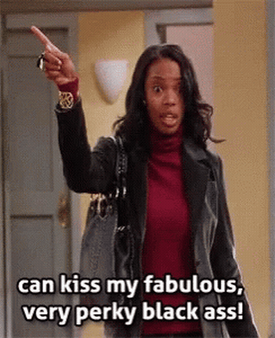 A Woman In A Red Turtleneck And Black Jacket Is Pointing At The Camera And Saying Can Kiss My Fabulous Very Perky Black  GIF