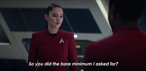 A Woman In A Red Uniform Is Talking To A Man In A Red Suit And Asking Him If He Did The Bare Minimum He Asked For GIF