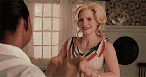 A Woman In A Red White And Blue Dress Is Talking To A Man In A White Shirt GIF
