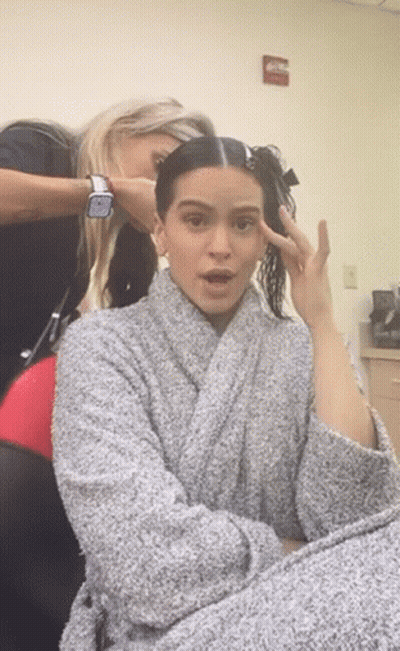 A Woman In A Robe Is Getting Her Hair Done By A Hairdresser GIF