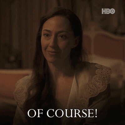 A Woman In A Robe Says " Of Course " In A Dark Room GIF