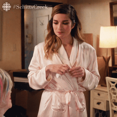 A Woman In A Robe With #Schittscreek Written On The Bottom GIF