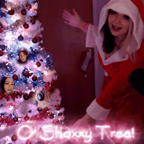 A Woman In A Santa Claus Costume Is Standing In Front Of A Christmas Tree GIF
