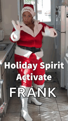 A Woman In A Santa Suit Is Standing In A Kitchen GIF