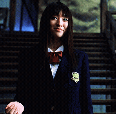 A Woman In A School Uniform Holding A Chain Around Her Neck GIF