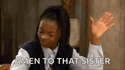 A Woman In A School Uniform Is Sitting At A Table With Her Hands In The Air And Says Amen To That Sister . GIF