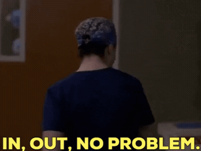 A Woman In A Scrub Top Is Standing In Front Of A Door And Says In Out No Problem GIF