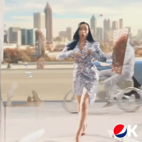 A Woman In A Sequined Dress Is Dancing In Front Of A Pepsi Sign GIF