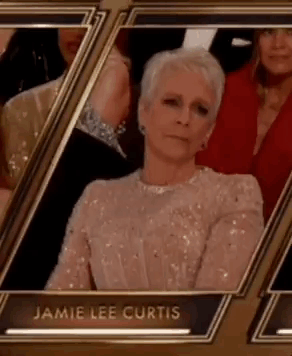 A Woman In A Sequined Dress Is Sitting In A Row Of Frames At An Event . GIF