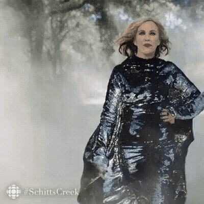 A Woman In A Sequined Dress Is Walking In The Fog . GIF