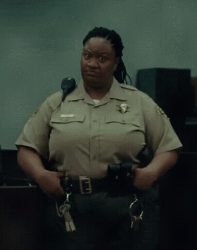 A Woman In A Sheriff 'S Uniform Holds A Pair Of Handcuffs And A Pair Of Keys GIF