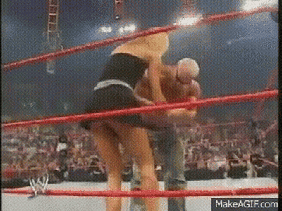A Woman In A Short Skirt Is Wrestling A Man In A Ring . GIF