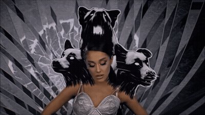 A Woman In A Silver Bra Is Surrounded By Black And White Drawings Of Animals GIF