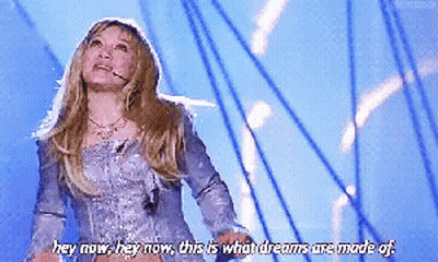 A Woman In A Silver Dress Says Hey Now Hey Now This Is What Dreams Are Made Of .. GIF