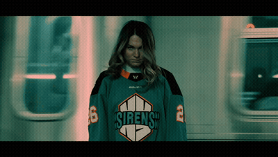 A Woman In A Sirens Jersey Is Standing In Front Of A Train GIF