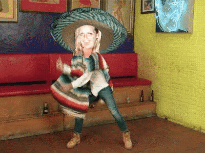 A Woman In A Sombrero And Poncho Is Dancing GIF