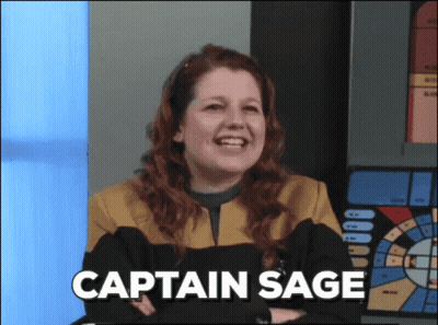 A Woman In A Star Trek Uniform Is Smiling With The Words Captain Sage Above Her GIF