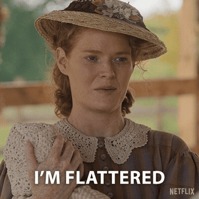 A Woman In A Straw Hat Holds A Baby And Says " I 'M Flattered " GIF