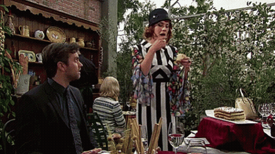 A Woman In A Striped Dress Is Eating A Piece Of Cake While A Man Looks On GIF