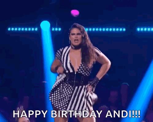A Woman In A Striped Dress Is Singing Into A Microphone And Says Happy Birthday And !! GIF
