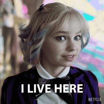 A Woman In A Striped Jacket And Bow Tie Says I Live Here GIF
