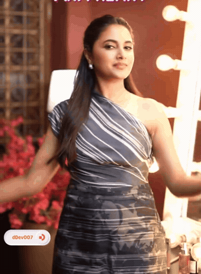 A Woman In A Striped One Shoulder Dress Is Standing In Front Of A Mirror With Ddev007 Written On The Bottom Right GIF