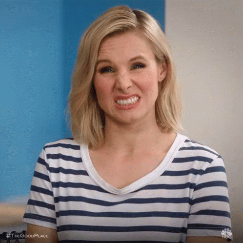 A Woman In A Striped Shirt Is Making A Face . GIF