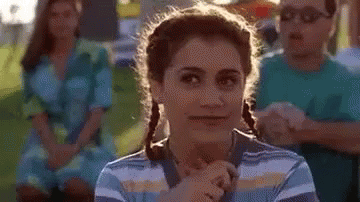 A Woman In A Striped Shirt Is Making A Funny Face . GIF