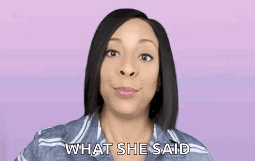A Woman In A Striped Shirt Is Smiling And Asking What She Said . GIF