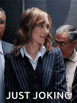 A Woman In A Striped Suit Is Standing In Front Of A Group Of People . GIF