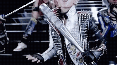 A Woman In A Studded Jacket Holds A Metal Bat GIF