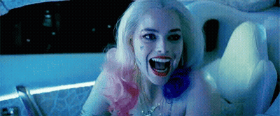 A Woman In A Suicide Squad Costume Is Sitting In A Tub With Her Mouth Open . GIF