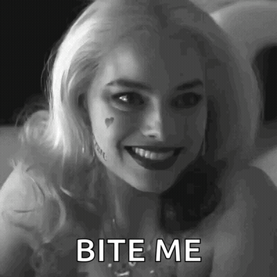 A Woman In A Suicide Squad Costume Is Smiling And Says Bite Me . GIF
