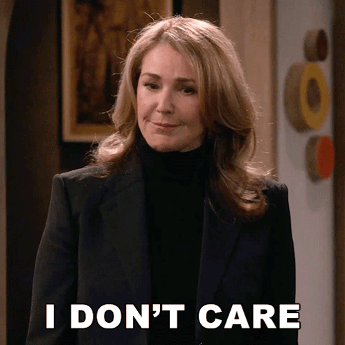 A Woman In A Suit And Black Turtleneck Says I Don 'T Care GIF
