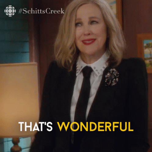 A Woman In A Suit And Tie Is Smiling With The Words That 'S Wonderful Below Her GIF