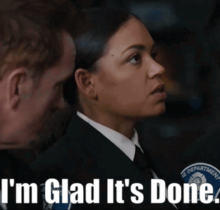 A Woman In A Suit And Tie Is Standing Next To A Man With The Words I 'M Glad It 'S Done Below Her GIF