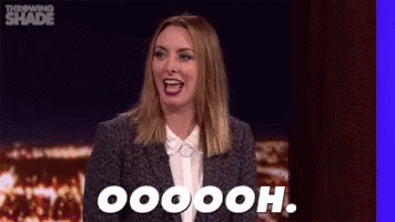 A Woman In A Suit And White Shirt Is Laughing And Saying Oooh . GIF